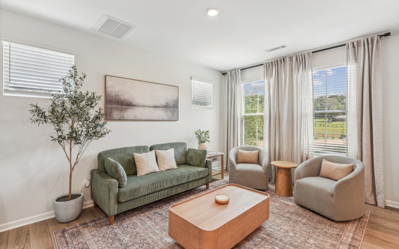 living room with couch and chairs and large windows